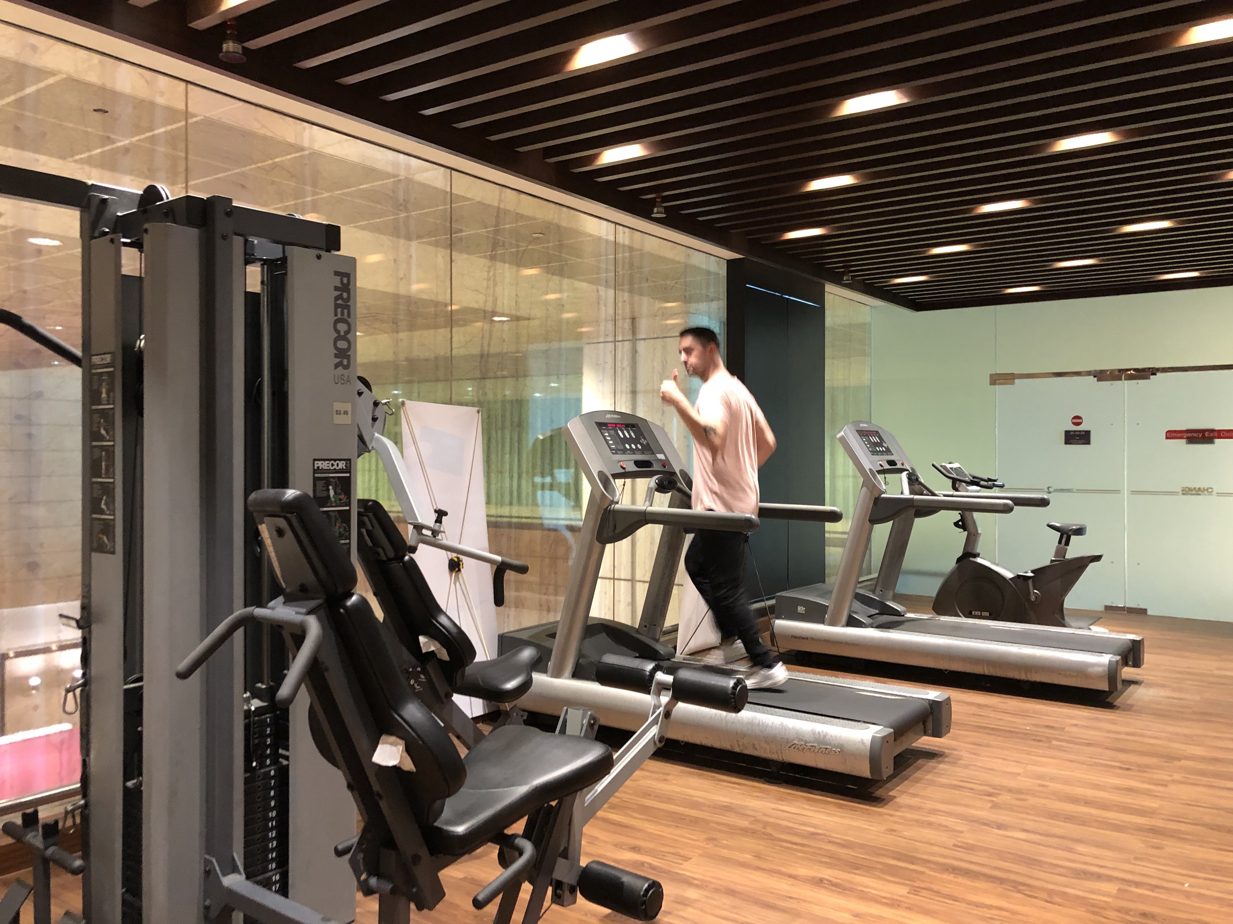 a man gives a thumbs up to the camera while running on a treadmill