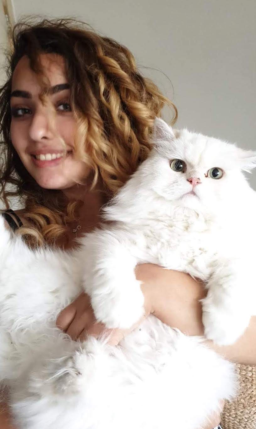 Sedra holding her white and very fluffy cat Jack.