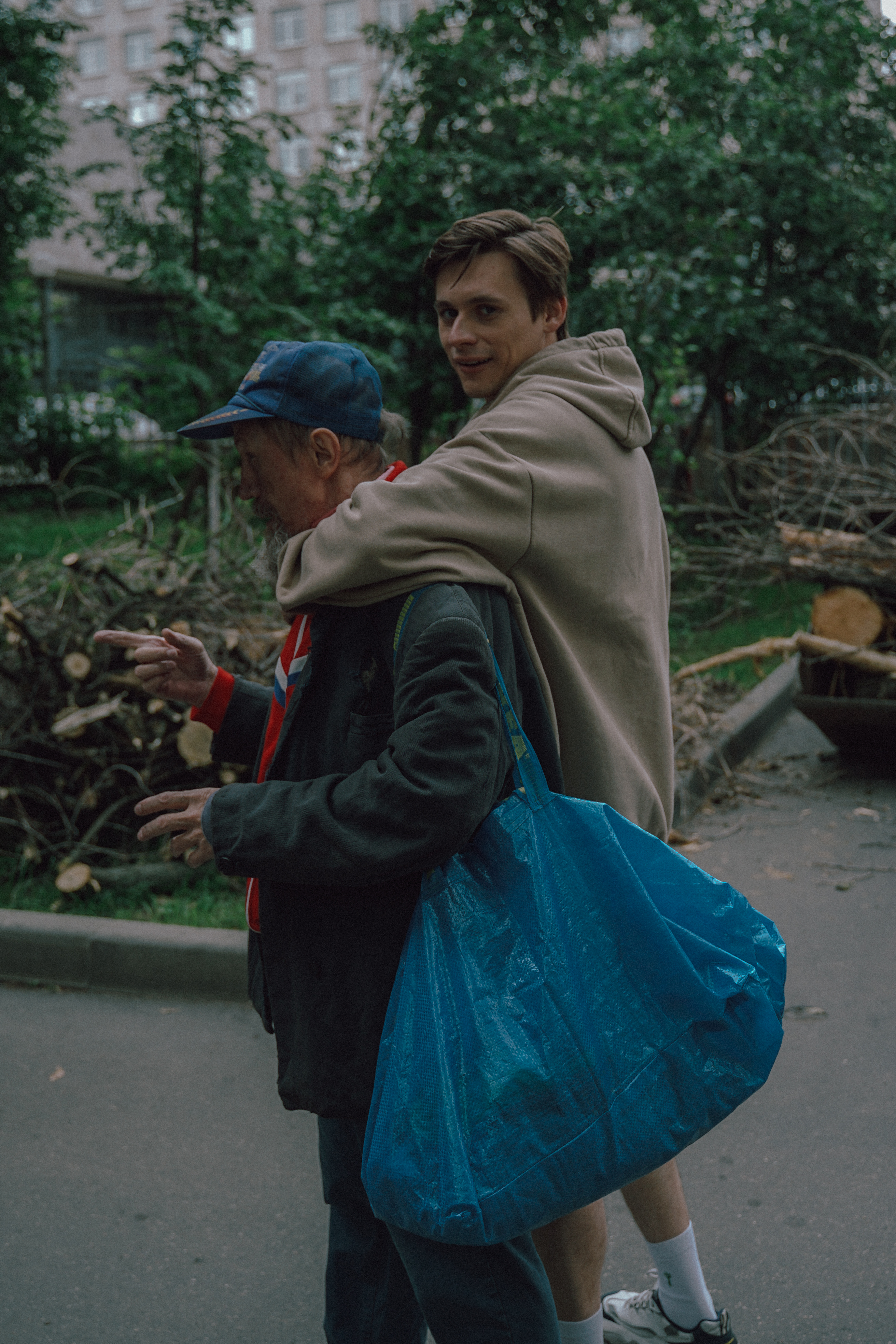 Here I Come - a young man huggs an older man carrying an ikea bag.