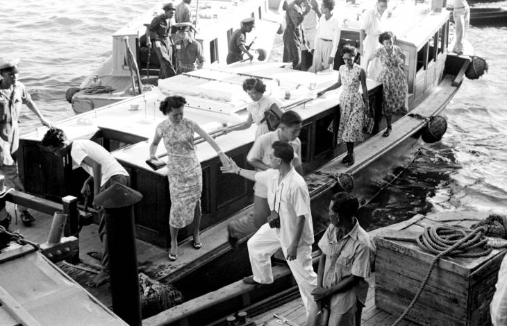 passengers of boat at a dock in 1950s singapore