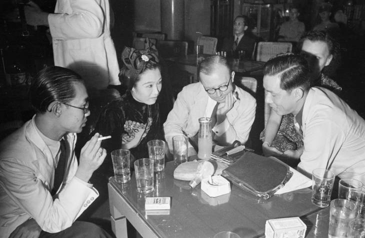 men and women drinking and smoking at a nightclub in 1940s singapore