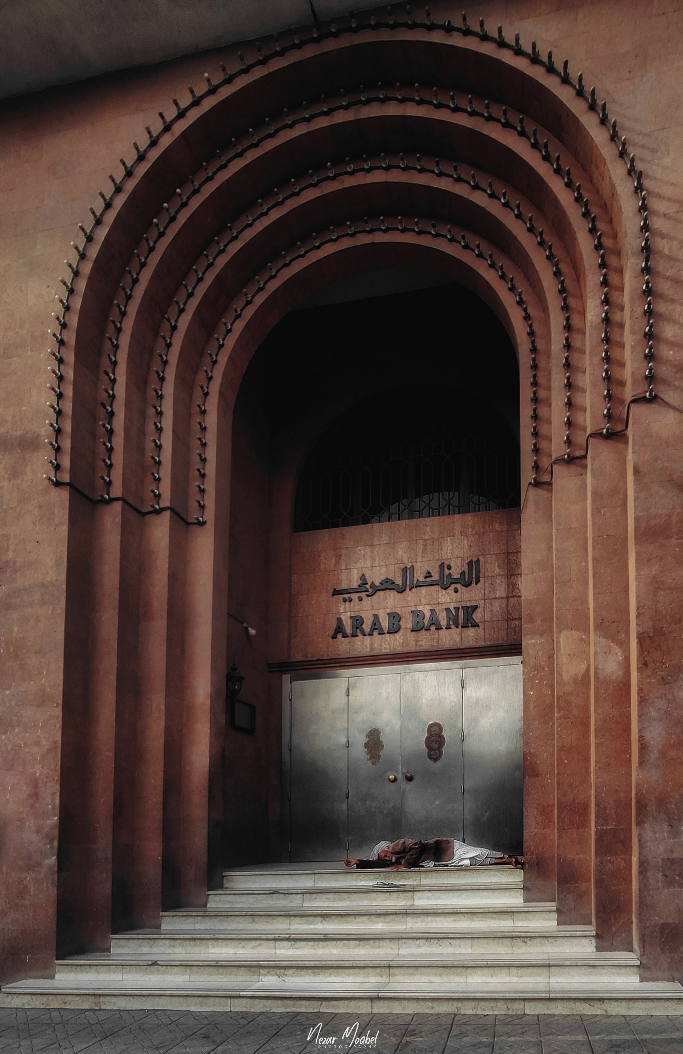 SANAA, YEMEN 2019 - uomo che dorme sugli scalini della Arab Bank, in Yemen