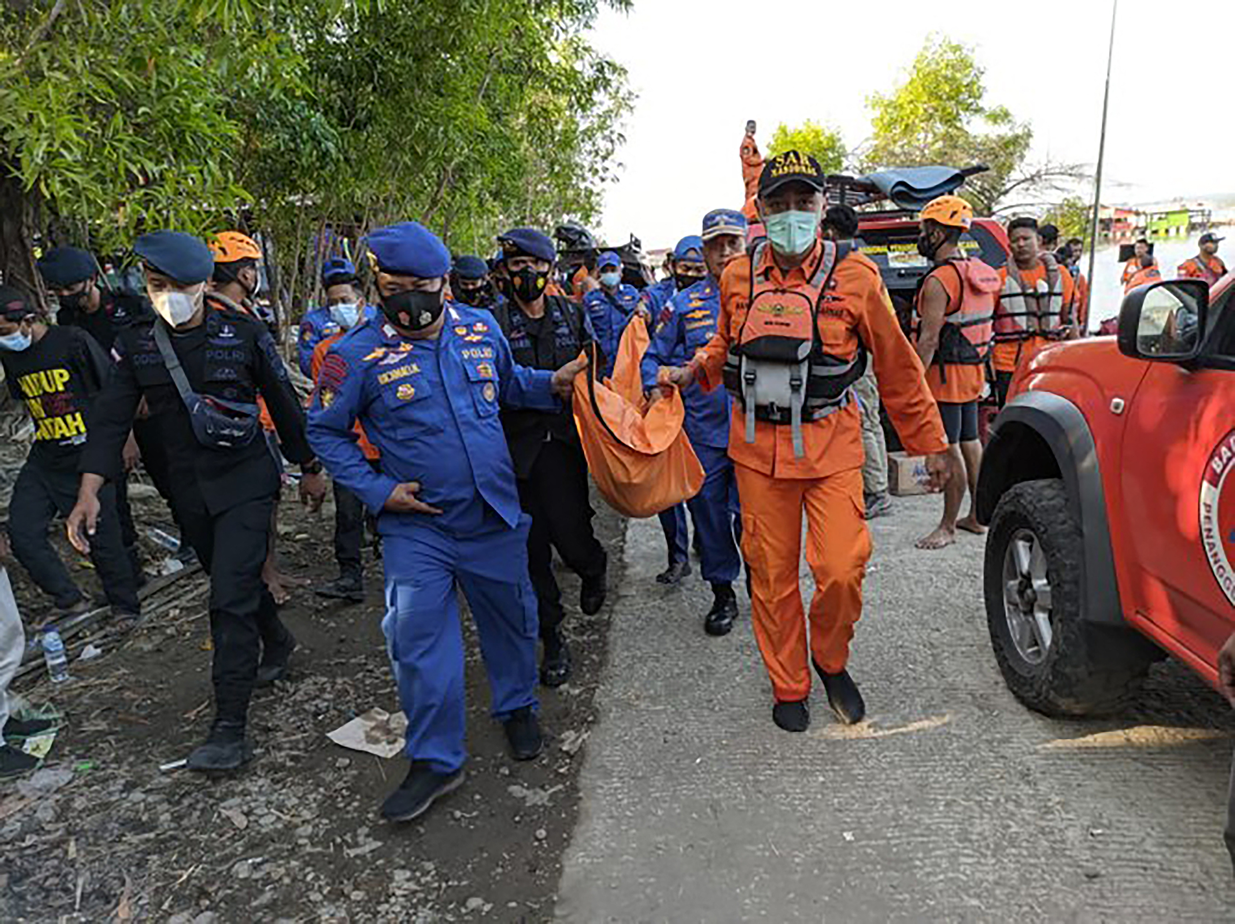 Rescuers carrying the body of a victim (PHOTO: National Search and Rescue Agency (BASARNAS) / AFP)