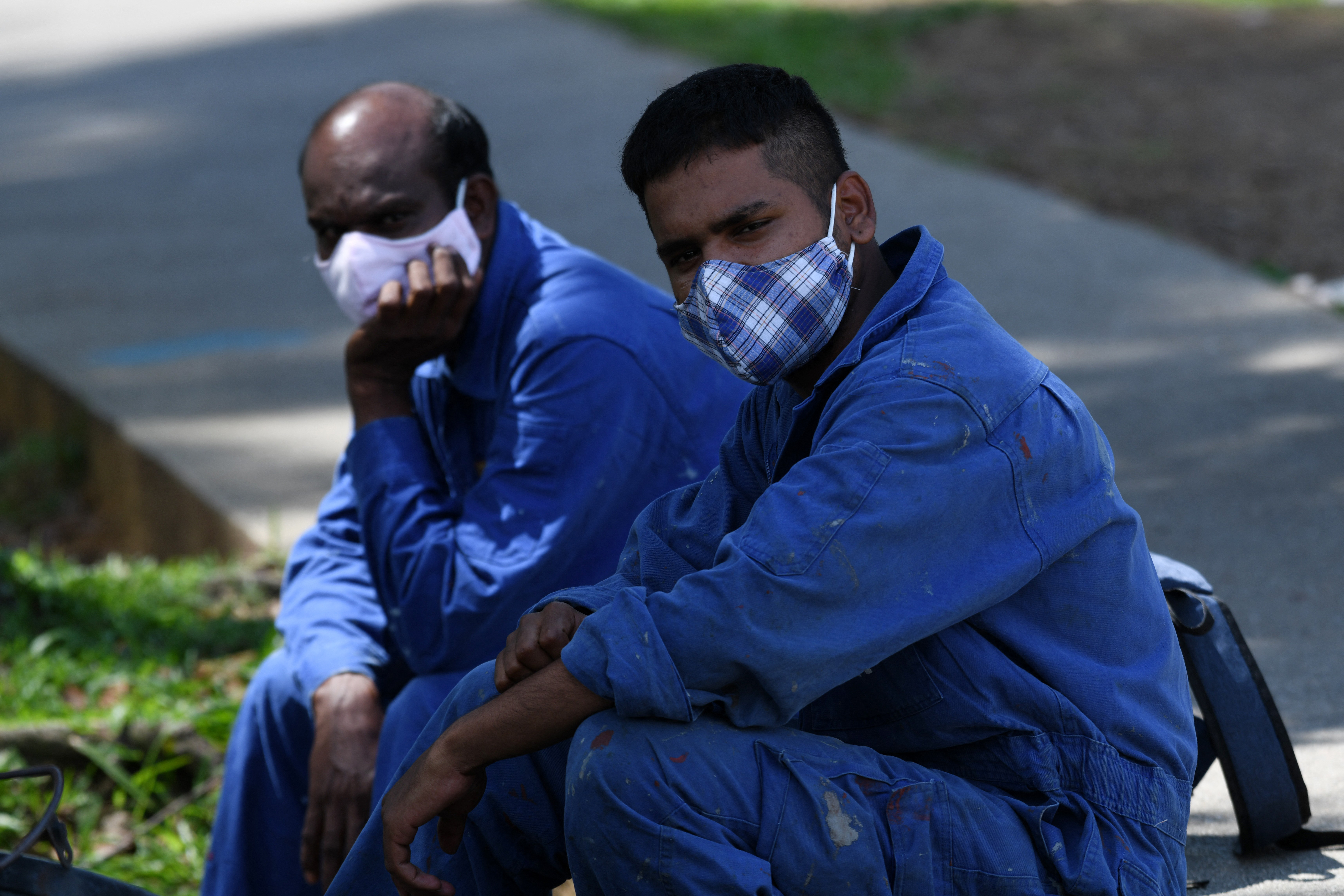 Migrant workers take a break. Photo: Roslan Rahman / AFP