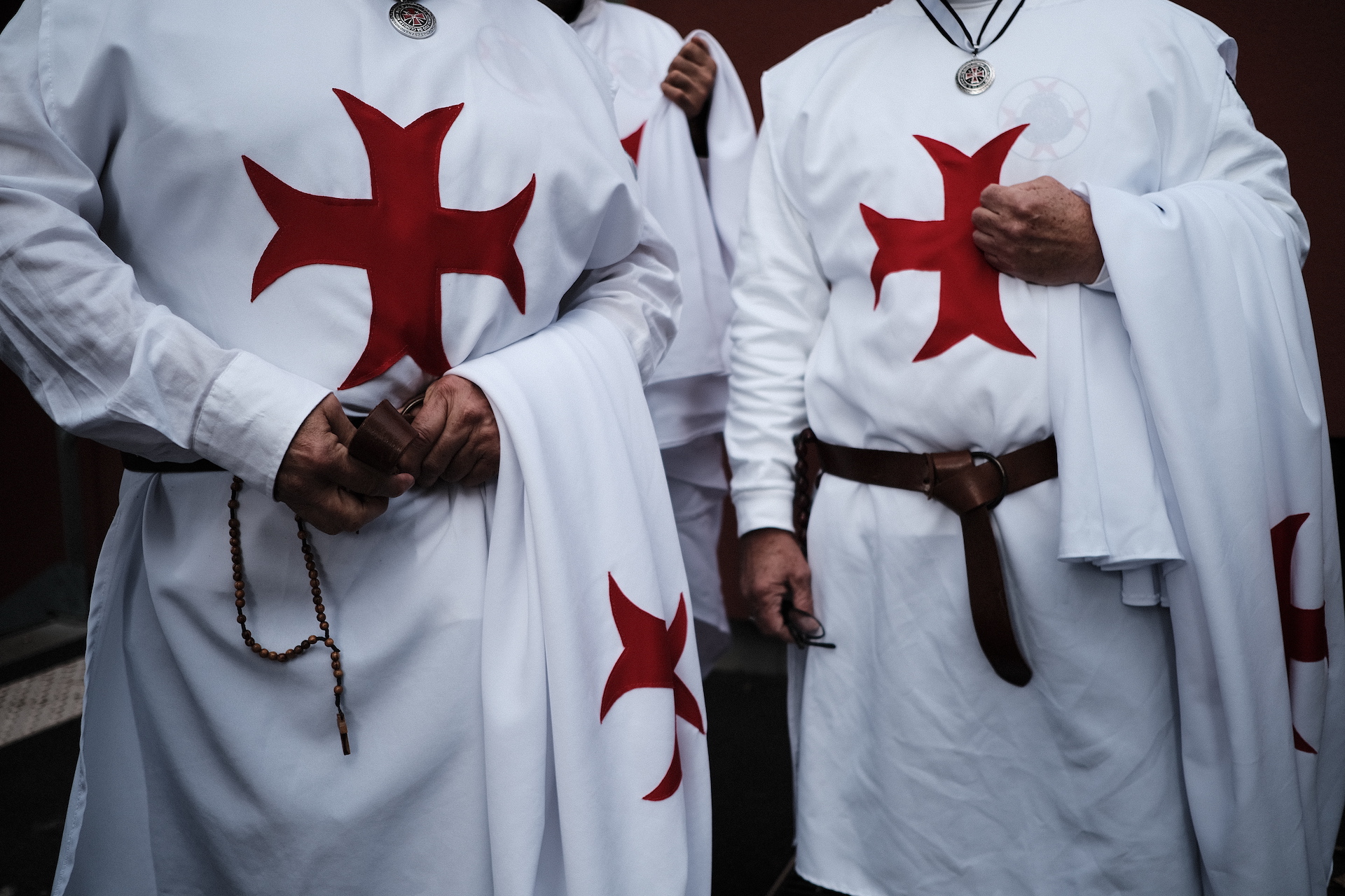 Männer in weißen Roben mit dem Templerkreuz