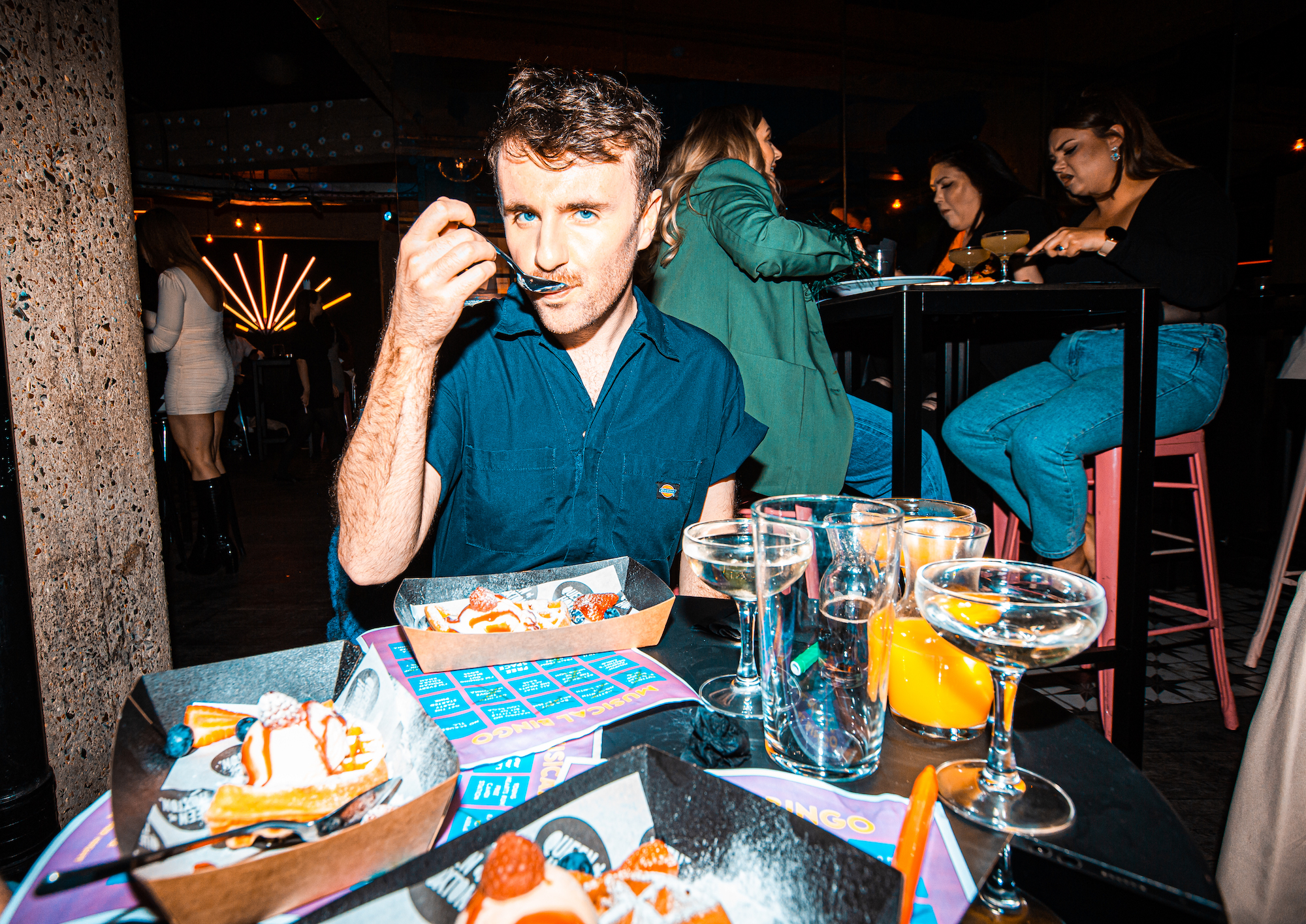 A man eating at drag brunch at Queen of Hoxton