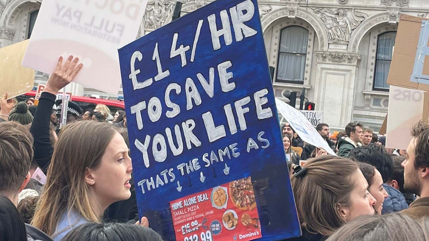 A photo of a placcard at the junior doctor strike which says '£14/hour to save your life'
