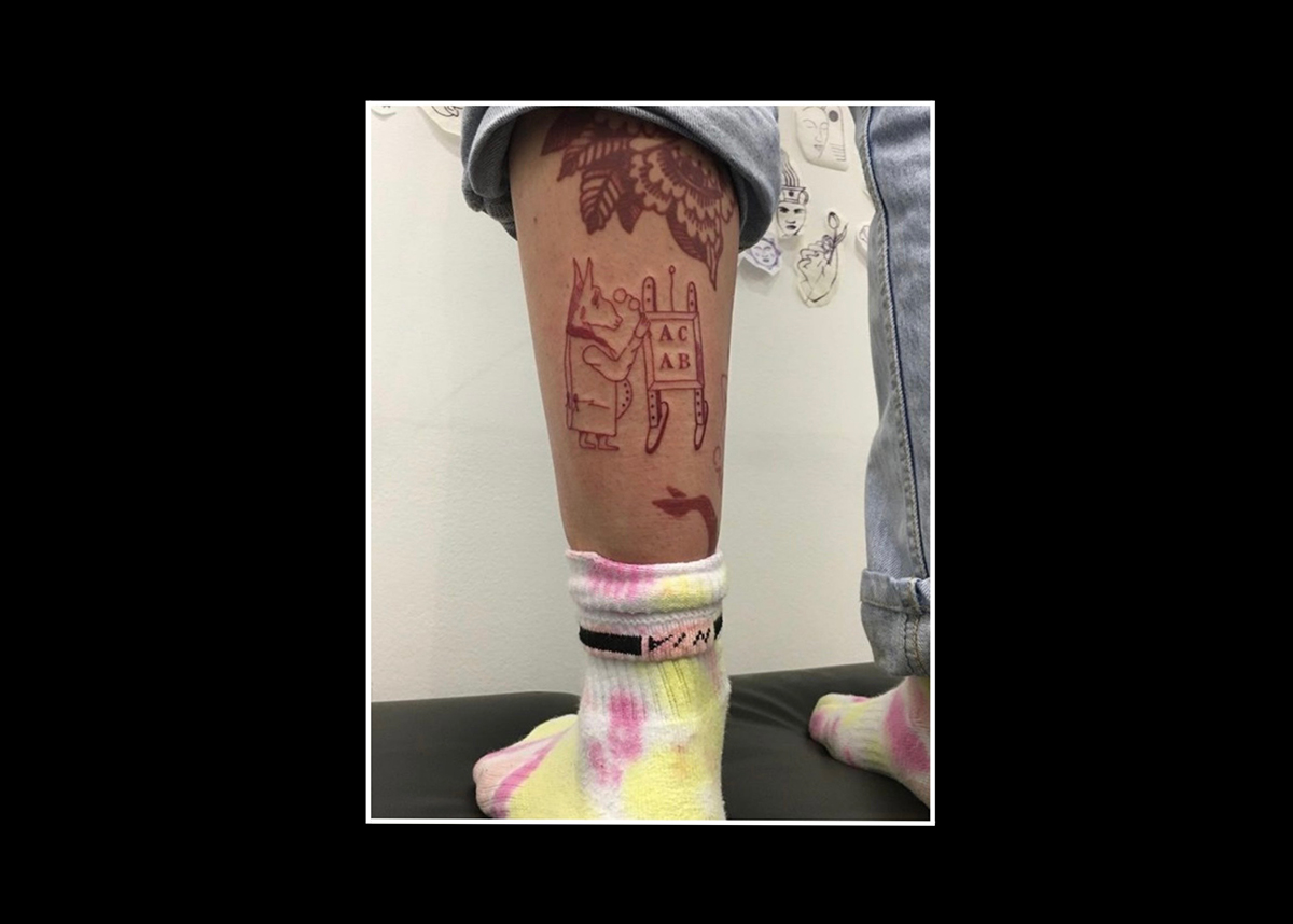 ACAB tattoos – red ink drawing of a donkey dressed in 19th century aristocratic clothes and carrying spectacles, looking at an elementary school blackboard with